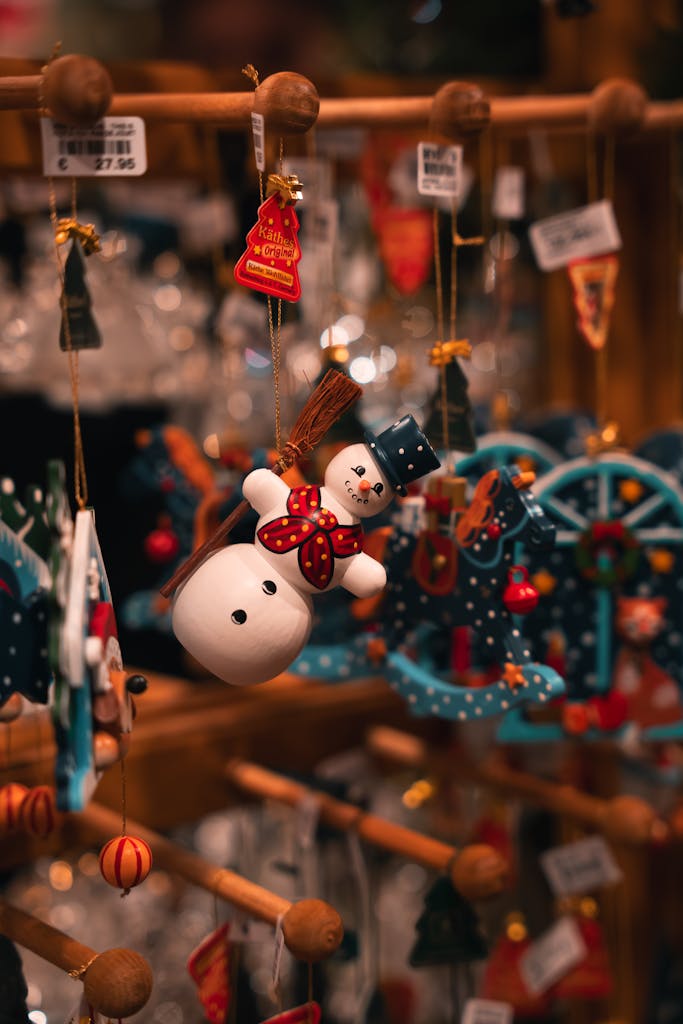 Charming snowman ornament hanging at a Berlin Christmas market, surrounded by festive decorations.