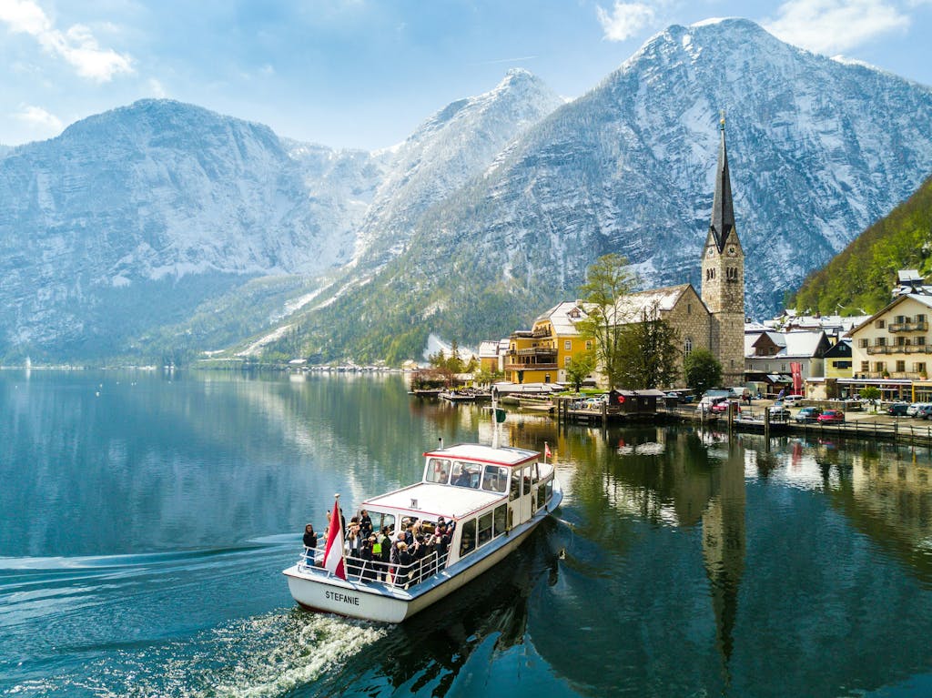 Stunning view of Hallstatt with a boat on the lake framed by snowy mountains.